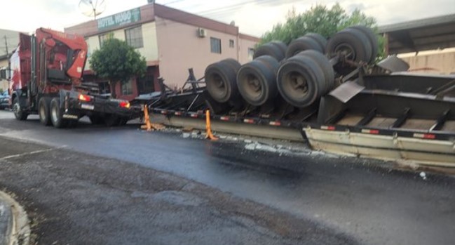 Caminhão carregado com postes de concreto tomba no centro