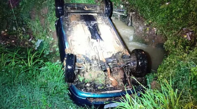 Motorista é resgatado pela Polícia Militar após ficar preso em carro que capotou e caiu dentro de córrego no Paraná