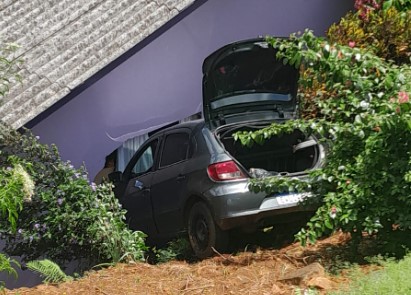 Veículo estacionado desce ladeira e atinge residência