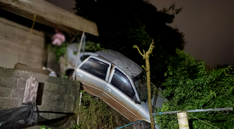 Carro sai da pista, desce barranco e atinge muro de residência