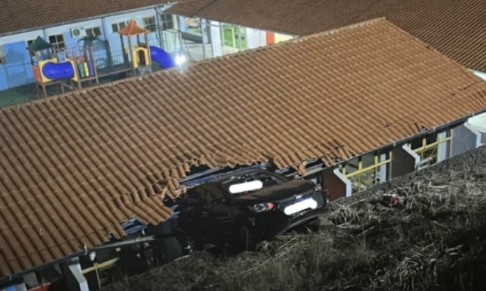 Carro sai da pista, desce ribanceira e bate em escola