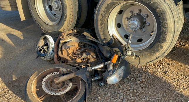 Motocicleta fica presa em rodado de caminhão após colisão