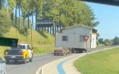 Casa de madeira é transportada por caminhão com escolta policial no sudoeste do Paraná