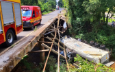 Caminhoneiro é socorrido em estado grave após carreta despencar dentro de rio