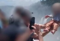 Homem ergue bebê sobre grade em mirante das Cataratas do Iguaçu para tirar foto