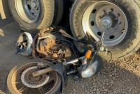 Motocicleta fica presa em rodado de caminhão após colisão