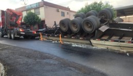 Caminhão carregado com postes de concreto tomba no centro