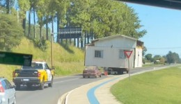 Casa de madeira é transportada por caminhão com escolta policial no sudoeste do Paraná