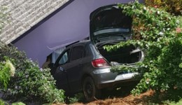 Veículo estacionado desce ladeira e atinge residência