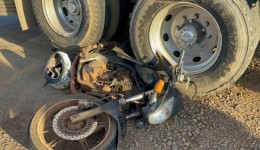 Motocicleta fica presa em rodado de caminhão após colisão