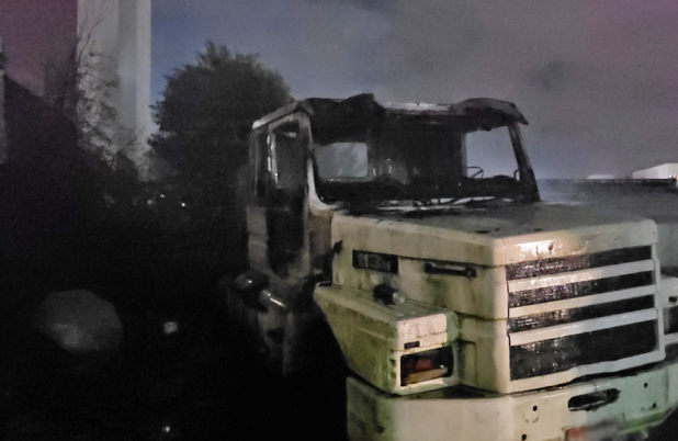 Incêndio atinge caminhão em terreno durante a noite