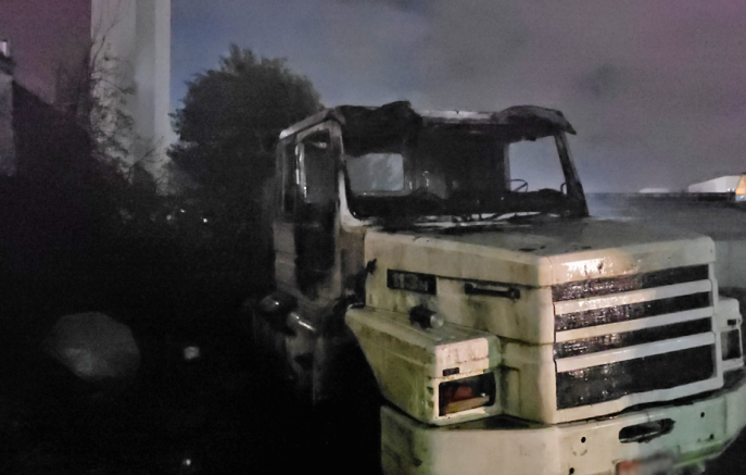 Incêndio atinge caminhão em terreno durante a noite