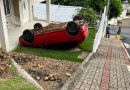 Carro desgovernado fica com rodas para cima após bater em muro de residência