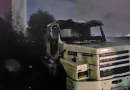 Incêndio atinge caminhão em terreno durante a noite