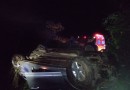 Mulher é socorrida por populares após sair da pista e capotar carro