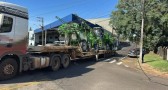 Caminhão que transportava máquina agrícola enrosca em fios e interdita cruzamento