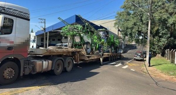 Caminhão que transportava máquina agrícola enrosca em fios e interdita cruzamento