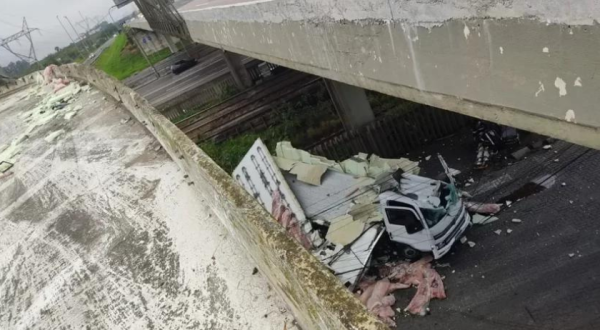 Caminhão que transportava carga de carne cai de cima da alça de acesso à freeway