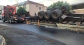 Caminhão carregado com postes de concreto tomba no centro
