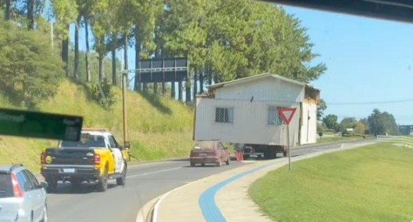 Casa de madeira é transportada por caminhão com escolta policial no sudoeste do Paraná