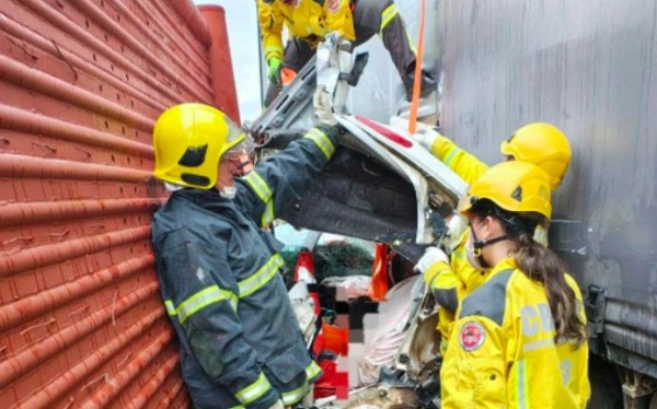 Carro fica irreconhecível após ser prensado por caminhões, mas motorista sobrevive