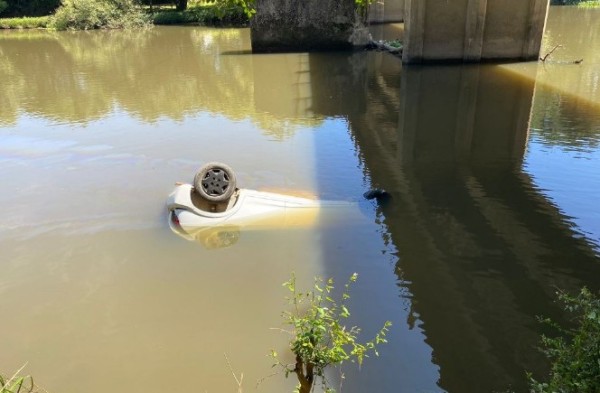 Carro bate em veículo estacionado, cai em rio e motorista morre