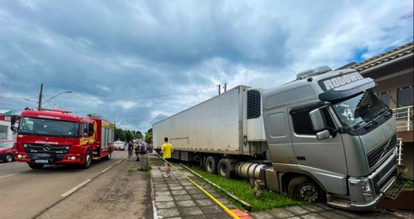 Carreta desgovernada bate em carro, sobe na calçada e invade pátio de duas residências