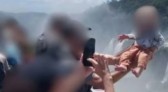 Homem ergue bebê sobre grade em mirante das Cataratas do Iguaçu para tirar foto