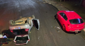 Carro bate em veículo estacionado e capota em avenida de SC