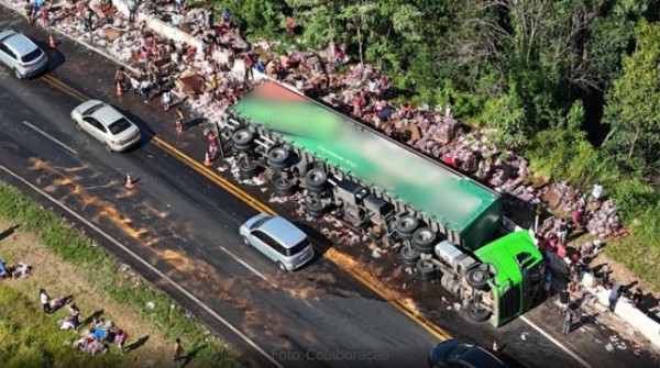 Caminhão com carreta carregada com energético e whisky tomba e carga é saqueada