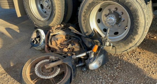 Motocicleta fica presa em rodado de caminhão após colisão