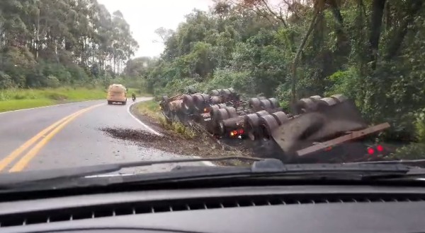 Carreta bitrem carregada com adubo sai da pista e tomba na BR-163